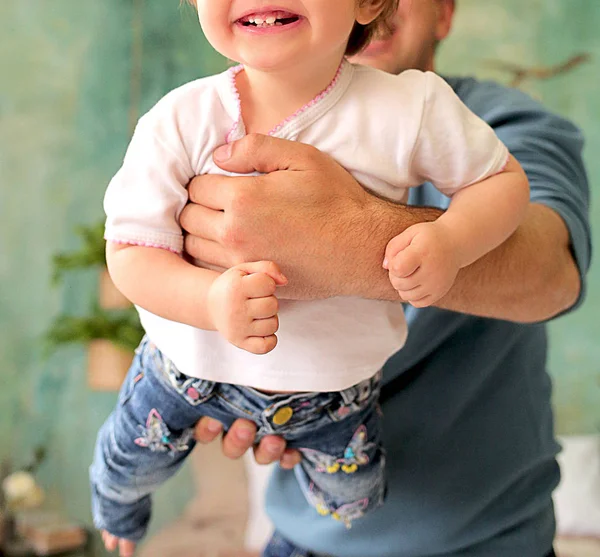 Klein meisje in blauwe jeans vliegt in de armen van papa — Stockfoto