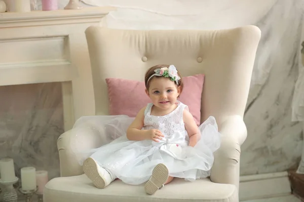 Linda Menina Vestido Branco Com Pente Pequeno Senta Uma Cadeira — Fotografia de Stock