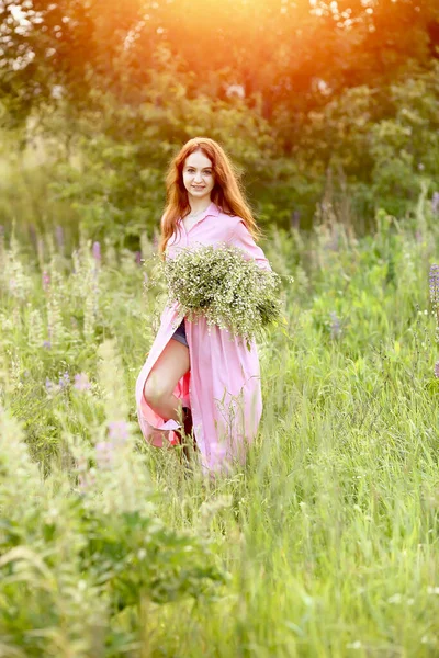 Fiatal Gyönyörű Vörös Hajú Lány Rózsaszín Ruhában Hatalmas Csokor Százszorszépséggel — Stock Fotó
