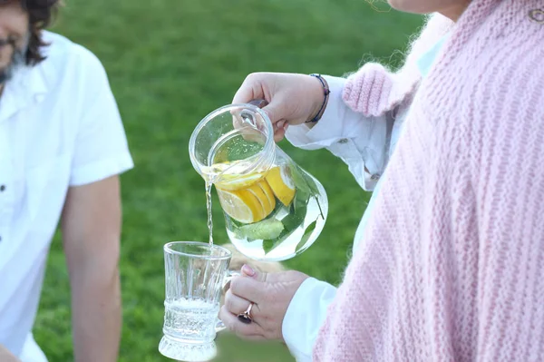Woman Outdoors Pink Knitted Cardigan Pours Cold Lemonade Glass Family — Stock Photo, Image