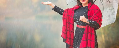 Sis dolu bir sonbahar gününde gölün kenarında kırmızı bir eşarp ve puantiyeli şık siyah elbisesi olan çekici olgun bir bayanla pankart. 40 yıl sonra bir kadının hayatı.