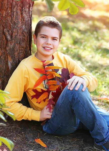 지안의 소년은 꽃다발들고 공원에 근처에 노란색 긴소매 셔츠와 청바지를 것들에 — 스톡 사진