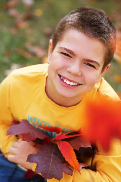 노랗게 셔츠를 나뭇잎을 꽃다발로 공원에 잘생긴 코카서스 청소년 소년의 — 스톡 사진