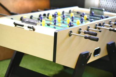 Çocuk oyunu. Her iki takımın futbolcularının figürleriyle dolu masa futbolu. Gençler için oyun odasındaki tahta bir kutuda. Çocuklar için masa oyunları.