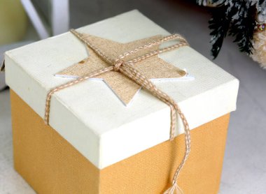 Kare şeklinde bir bej hediye kutusu. Yeni yıl arifesinde yakın plan duruyor. Noel arifesi. Kış. Hediyeler konsepti.