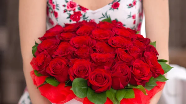 Bouquet of red roses in a white box in the hands of a woman — Stock Photo, Image