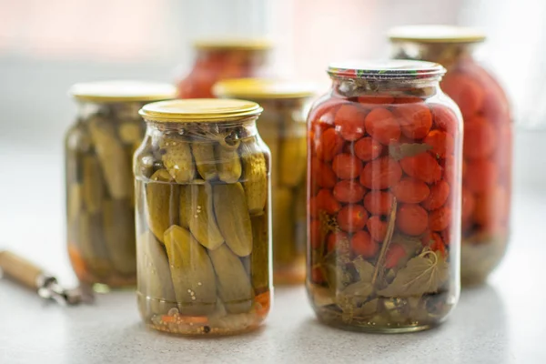Ogórków marynowanych i pomidorów w słoiku szklanym na białym tle z otwieraczem — Zdjęcie stockowe
