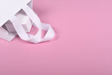 Pembe arka plan üzerinde beyaz hediye çantası beyaz hediye kutusu