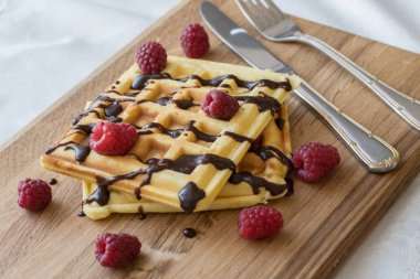 Ahşap bir Tahta üzerinde çikolata ve çilek ile iki Viyana waffle