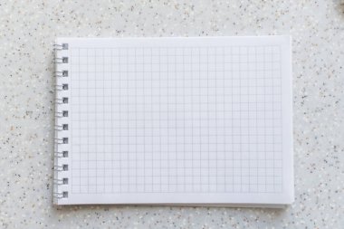 Kafesteki beyaz defter, yakın plan sarmal çekimde.