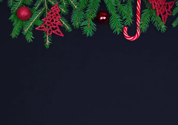Sparren takken, kerstballen, snoep op zwarte achtergrond, voorbereidingen voor het nieuwe jaar. bovenste weergave, kopieer spase — Stockfoto