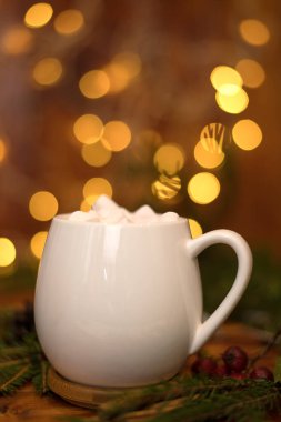 Beyaz bir fincanda kakao içmek, arka planda marşmelov, sıcak Noel içeceği.