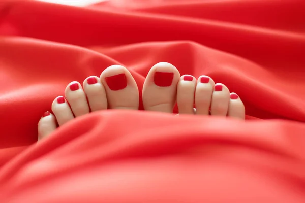 Dedos femininos com pedicure vermelho de baixo das coberturas vermelhas Close-up de pés femininos cobertos com pedicure vermelho — Fotografia de Stock