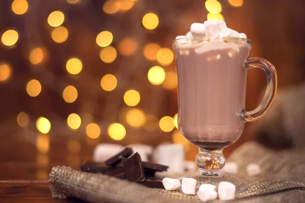 Bebida de cacao en un vaso con malvavisco en el fondo de luces bokeh, bebidas calientes de Navidad — Foto de Stock