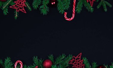 Spruce dalları, Noel baloları, siyah arka planda şekerler, yeni yıla hazırlık. Üst görünüm, kopyala spase, taklit et