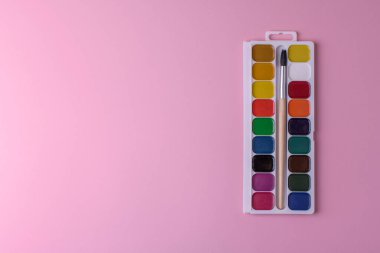 Bal rengi suluboya ve pembe arka planda fırça ile dikdörtgen kutu paleti, üst görünüm