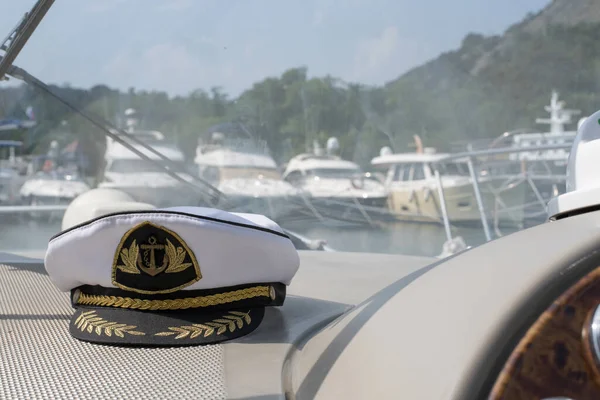 White sea captains cap on the dashboard of the boat