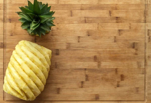 Ripe, juicy, yellow perfectly peeled pineapple, on a wooden background. — Stock Photo, Image