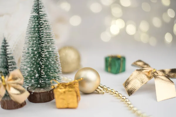 Dos pequeños árboles de Navidad decorados y regalos para el nuevo año en el fondo bokeh, composición de año nuevo — Foto de Stock
