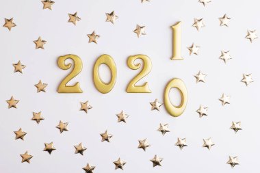 Mutlu yıllar 2021. 2020 yılı parlayan rakamları beyaz arka planda izole edilmiş. Tatil tebrik kartı tasarımı için altın nesne.