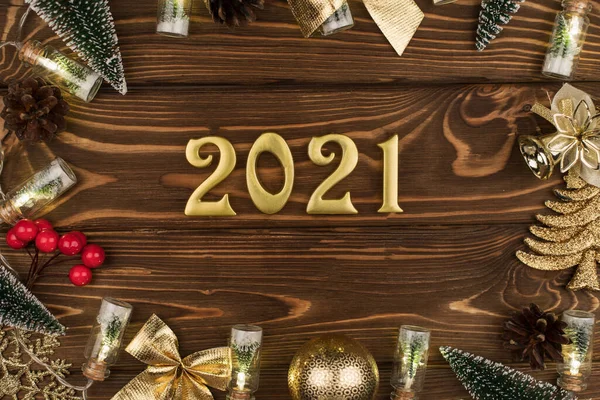 Новий 2021 рік. Золоті номери на дерев "яному фоні з новорічним декором. — стокове фото