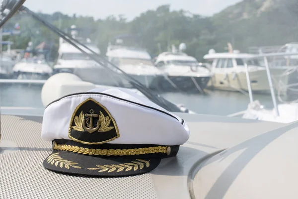 White sea captains cap on the dashboard of the boat