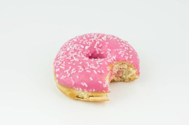 Lezzetli ısırıldı pembe çörek ile izole beyaz zemin üzerine beyaz çikolata parçacıklı