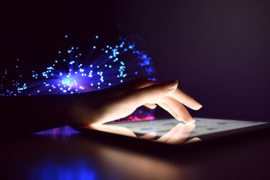 Kadın el Tablet ekran bulanık Fiber optik Bokeh arka plan teknoloji kavramı üzerinde Internet tarama dokunmadan