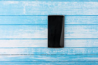 Yüksek kontrast mavi ve beyaz tahta arka plan en iyi açı yansıması ile siyah büyük ekran akıllı telefon