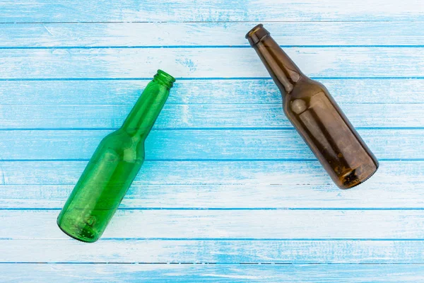 Gröna Och Bruna Tomma Ölflaskor Blå Vit Målade Trä Bakgrund — Stockfoto