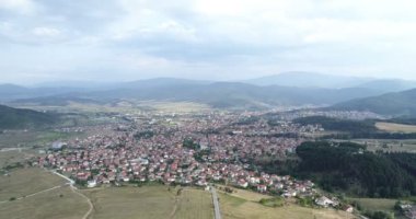 Yavaş hareket Over çam ağacı orman yanındaki küçük dağ Town evleri ile hava atış 