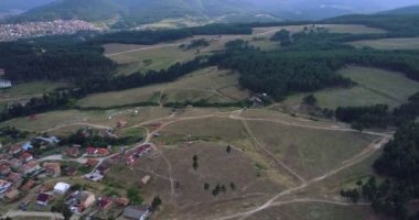 Yavaş hareket Over çam ağacı orman yanındaki küçük dağ Town evleri ile hava atış 