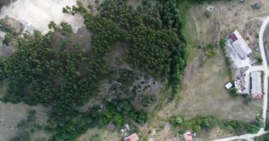 Yavaş hareket Over çam ağacı orman yanındaki küçük dağ Town evleri ile hava atış 