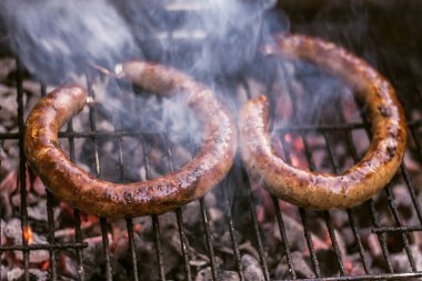Yemek ve sigara Closeup kömür ateşi altında ev yapımı sosis mangal