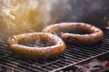 Yemek ve sigara Closeup kömür ateşi altında ev yapımı sosis mangal