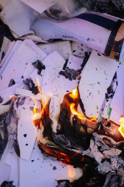 Açık havada yeşil yaz çimlerinde kağıt yanıyor..