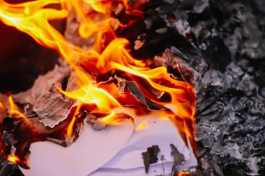 Açık havada yeşil yaz çimlerinde kağıt yanıyor..