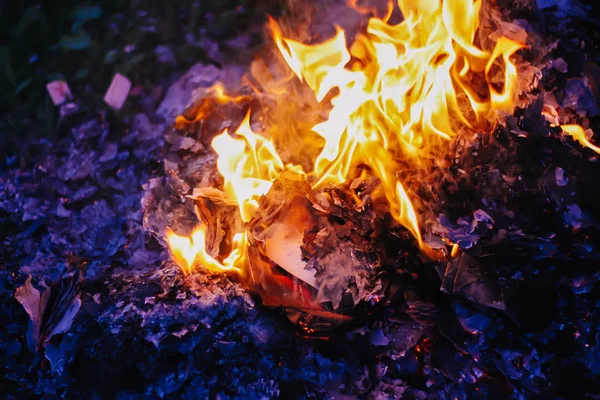 Paper burning on green summer grass outdoors. — Stock Photo, Image