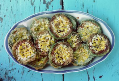 Sotelenmiş yaz ve kabak ezmesi mavi ahşap bir tabakta