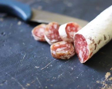 Eskimiş ahşap arka planda baharatlı kurutulmuş sosis..