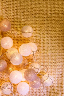 Noel ışıkları, örülmüş kumaş arkaplanda yuvarlak fenerlerle süslenir..