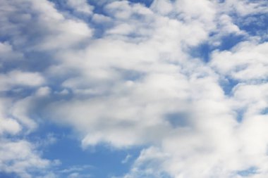 Sıcak yaz gününde beyaz kabarık bulutlu mavi gökyüzü arkaplanı.