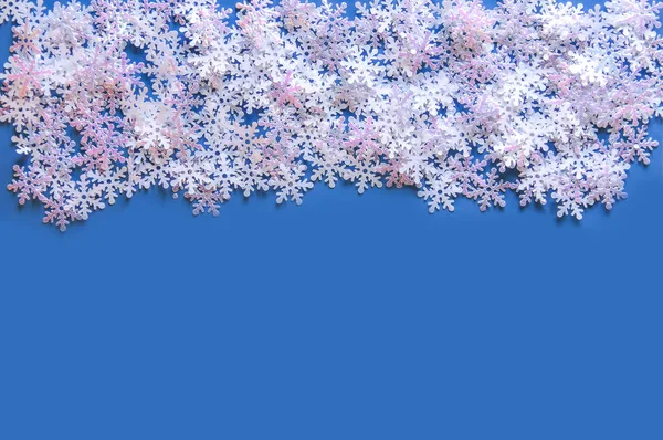 Weißer Kunstschnee auf blauem Hintergrund. Winterlicher Hintergrund. — Stockfoto