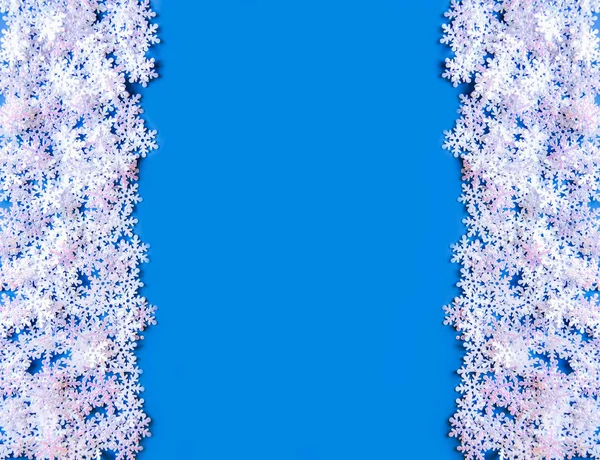 Weißer Kunstschnee auf blauem Hintergrund. Winterlicher Hintergrund. — Stockfoto