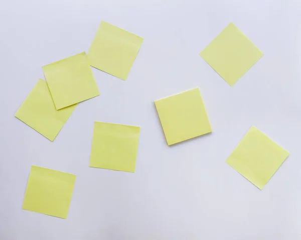 Group of yellow sticker notes on white background. Adhesive paper sheets for short business notes.