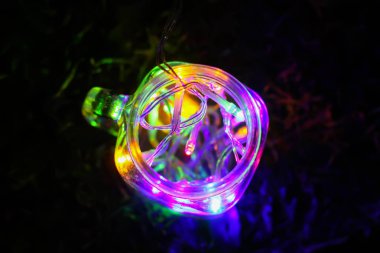 Gece karanlığında cam kavanozda parlak renkli çelenk ışıkları olan bir kart..