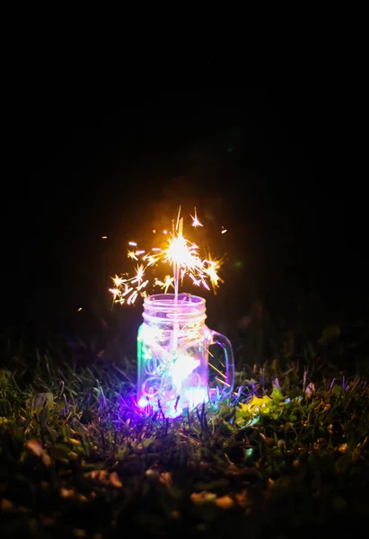 Świąteczna Kartka Jasnymi Kolorowymi Lampkami Girlandowymi Bengalskim Ogniem Szklanym Słoiku — Zdjęcie stockowe