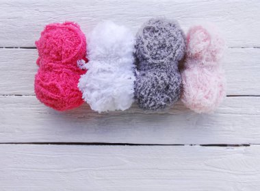 Ahşap arka planda parlak yün iplik derileri.