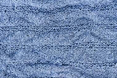 Doğal kumaş parçası. Örgü dokusu yakın çekim. Ilık yün iplik arka planı. Örgü numunesi..