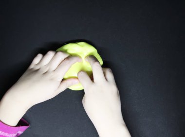 Elinde sarı sümükle oynayan bir kız..